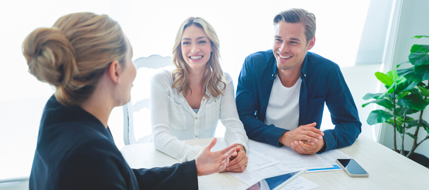 A real estate agent with a couple discussing the terms of the real estate documents