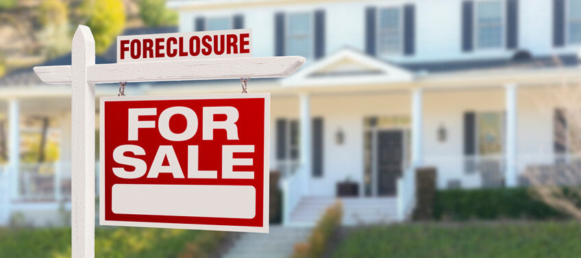 A foreclosure homes for sale sign in front of a single-family home