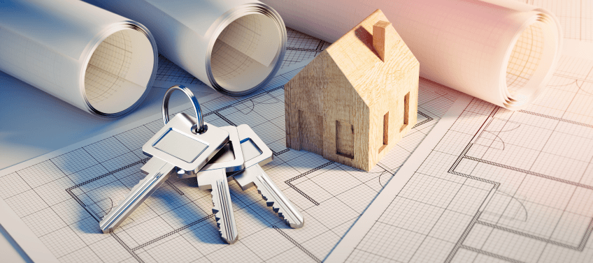 House keys and a wooden home model on top of blueprints, symbolizing a new home or property ownership.