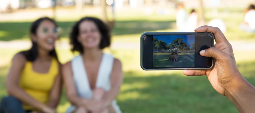 Real estate agents film casual social media content in an outdoor setting.