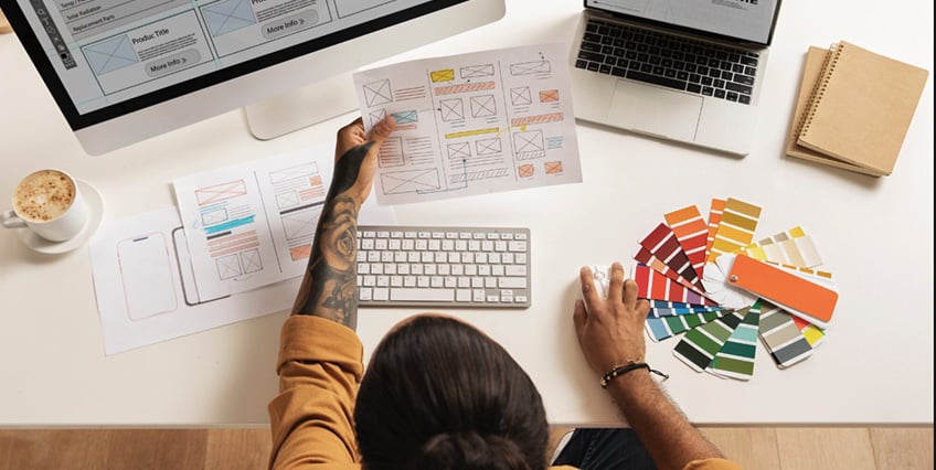 A website designer looking at printed wireframes.